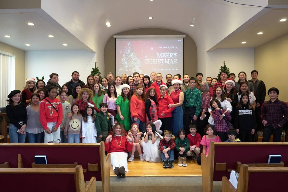 The congregation gathered on the sanctuary steps for a Christmas photo, with a Merry Christmas slide on the screen behind them