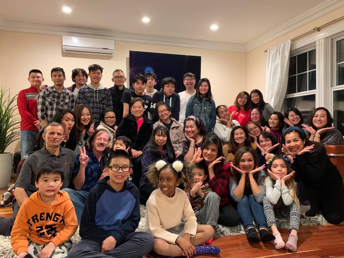 Three generations of the church family crowded into a living room for a group photo